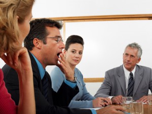 Businessman Yawning During Meeting At Conference Room